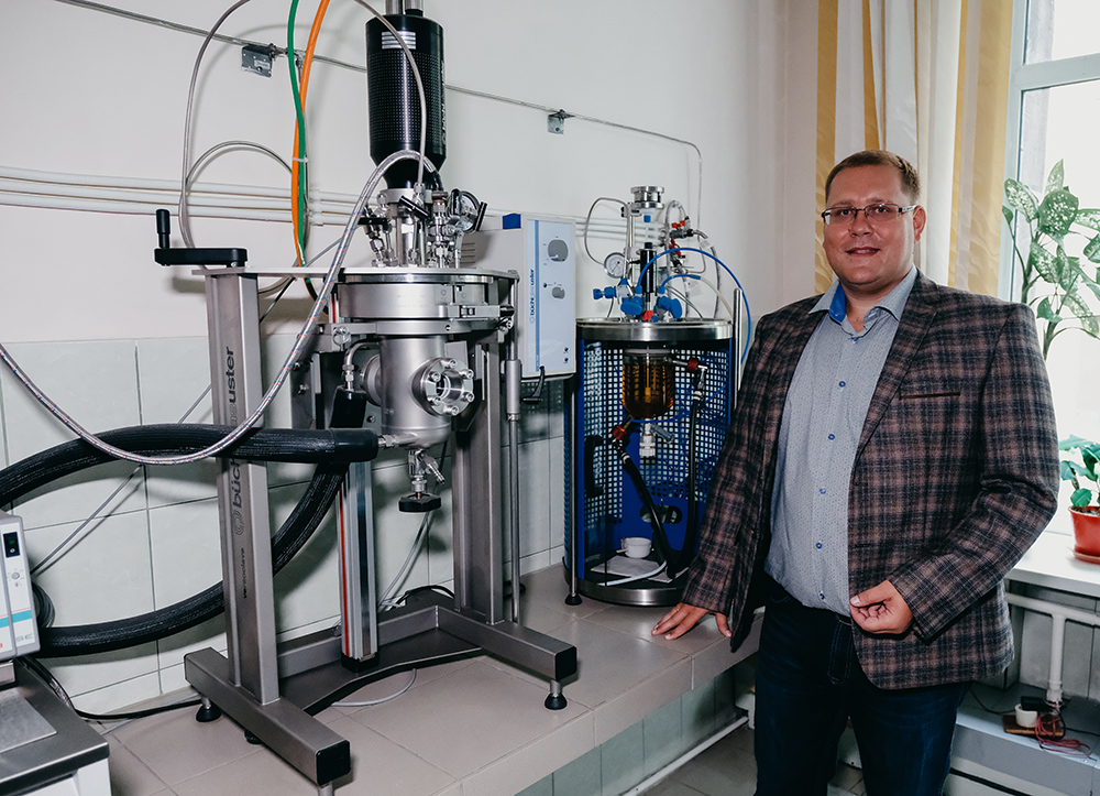 Roman Borisov, Senior Researcher at the Institute of Chemistry and Chemical Technology, with the glass reactor and autoclave.